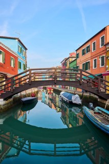 Colorful houses and a bridge 'Love viewing bridge' going over the waterway with boats lying in the