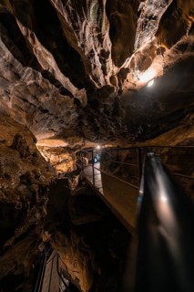 Illuminated path in a cave, surrounded by rocks and darkness, mysterious atmosphere, Beatus Caves,