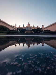 A serene and symmetrical reflection of the majestic National Art Museum of Catalonia in Barcelona
