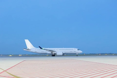 A sleek white airplane sits on a vast airport runway, capturing the tranquility of travel moments