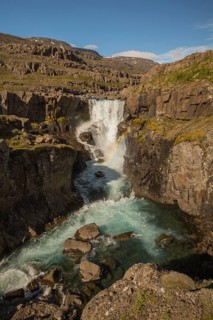 Fossardalur Waterfall with rainbow, close to Djupivogur at the Berufjord, Easter Iceland