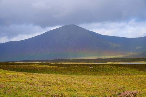 A large, cloud-covered mountain rises above a vast, grassy landscape, Rannoch Moor, Bridge of