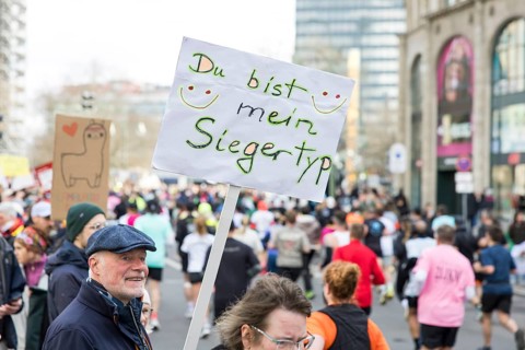 A man cheers on runners with his sign You're my type of winner! on Kurfürstendamm at the 45th