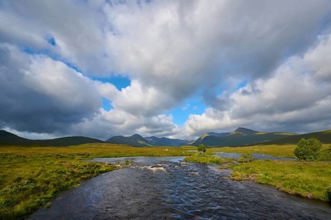 Wide river landscape under dramatic clouds and mountains in the background, Rannoch Moor, Bridge of
