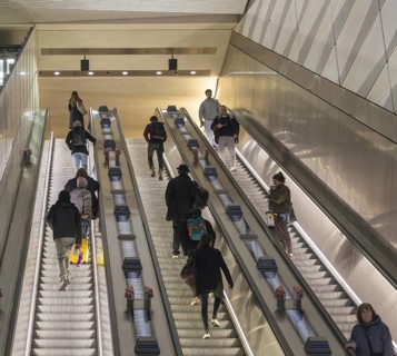 People on escalator Elizabeth Line, Liverpool Street underground railway station, London, England,