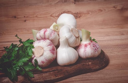 Fresh young garlic, white and purple color, on a wooden table, no people