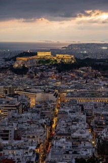 View over the sea of houses of Athens, illuminated Parthenon temple on the Acropolis, from Mount