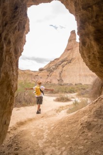 Vertical photo true an cave of a free man walking along a desert alone