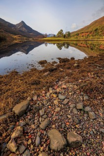 Mountains reflected in fjord, stones, midday light, sunny, still, coast, sea, autumn, autumn