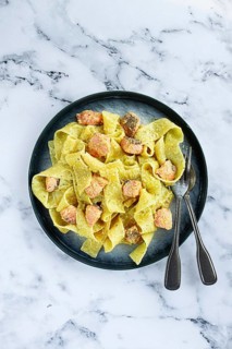 Papardelle pasta, in creamy sauce with salmon, natural light, lifestyle, homemade, on a gray