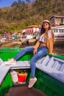 Portrait of a Latin woman with sunglasses sightseeing on a boat along the coast. Tourism in summer