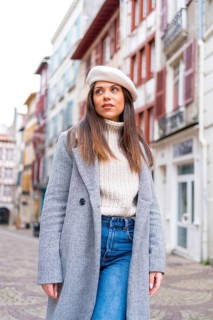 Vertical photo of a french style tourist standing in a street looking at views