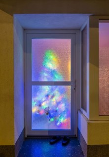 Reflection of a colourfully decorated Christmas tree in a pane of frosted glass in Düsseldorf,