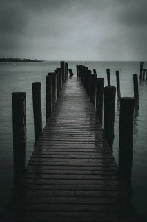 Jetty juts out into a gloomy, cloudy lake, Podersdorf, Burgenland, Austria