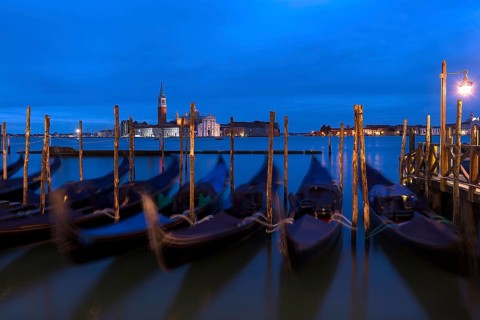 Nighttime atmosphere with moving gondolas, San Georgio Maggiore in the back, Guidecca Island on the
