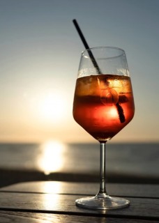 Glass of Aperol Spritz against the light at sunset