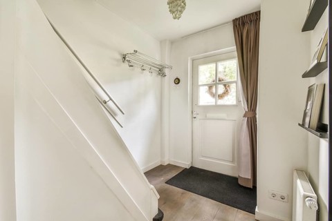 A stylish and welcoming entrance featuring a staircase, a doorway to the outside, and natural light