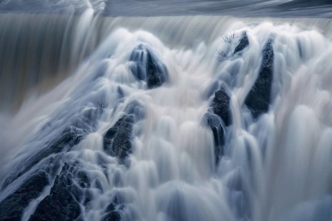 Cascading waters of Presa del Villar in Madrid captured using a long exposure technique, presenting