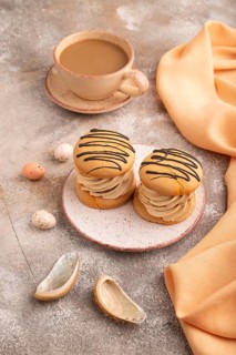 Caramel Cream Cakes on brown concrete background, cup of coffee, side view, close up