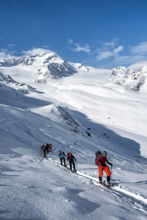 Ski tourers, behind the summit of Monte Cevedale, snow-covered mountain landscape, Ortler Alps,