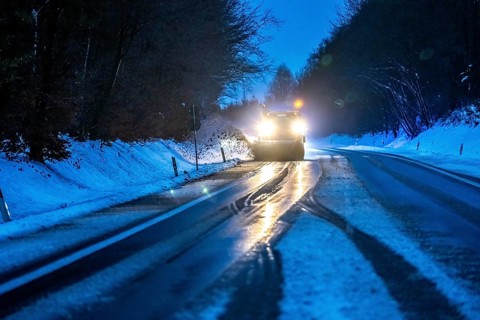Winter service, spreader and snow plough in use, clears snow and slush from a regional road,
