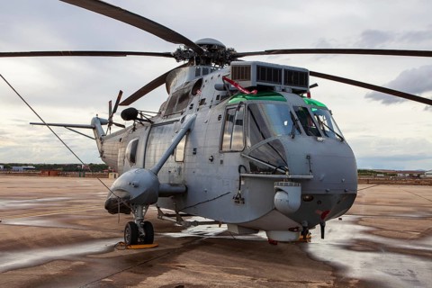 A large military helicopter is parked on the wet tarmac at Torrejon Air Base. The aircraft's