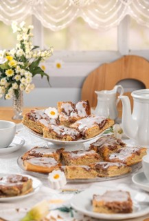 Homemade cake with icing on a table set with flowers in spring