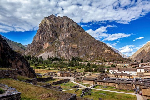 Village in front of a big mountain with clouds in the sky, old buildings, The Inca ruins of