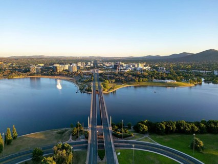 From above, a drone view of Canberra's cityscape, highlighted by meandering roads and the large