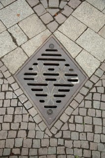 Manhole cover with city coat of arms and grey paving stones, floor, monochrome, Dernsches Gelände,