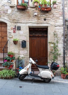 Vespa scooter in the streets of Assisi Old Town, Umbria, Italy