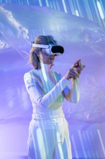 An elderly Asian woman engaging with the metaverse, wearing a VR headset. She navigates an
