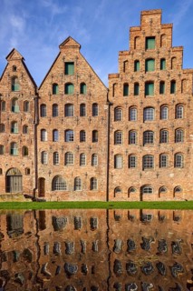 Historic salt storehouse, brick building with windows and doors against blue sky with veil clouds,