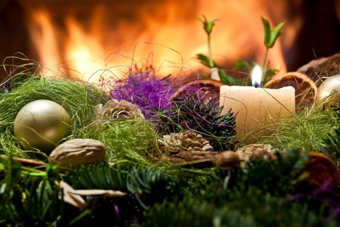 Christmas decoration with a candle and fireplace in the background in Poland