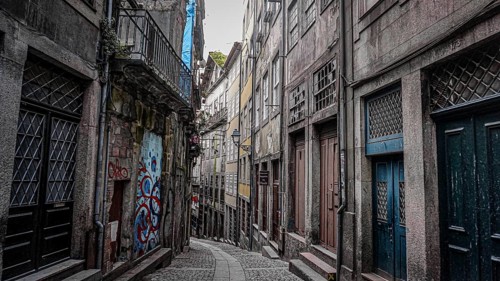 Narrow alley with cobblestones and historic buildings in the atmospheric old town of Porto,