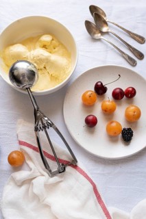 Top view of a refreshing dessert layout with a bowl of creamy vanilla ice cream, a plate of vibrant