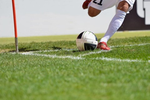 Football player kicks ball from the corner, detail, in Lubin, Poland