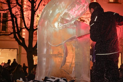 An ice sculpture is being created: ice carving street action as part of the long shopping night in