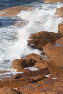 Crashing wave at Lighthouse Mean Ruz at Ploumanach, Cotes d'Armor in the evening light