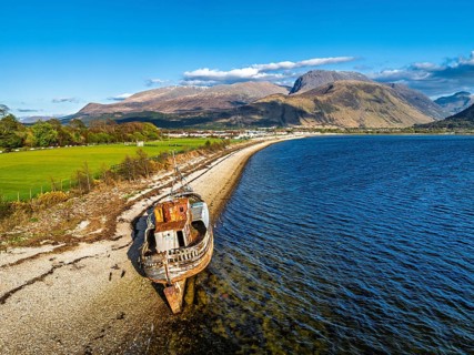View of Corpach Wreck or Old Boat of Caol and Nevis Range Mountains from a drone, Caol Beach,