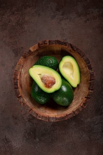 Fresh, sliced avocado, in a wooden plate, top view, food background, concept, food styling