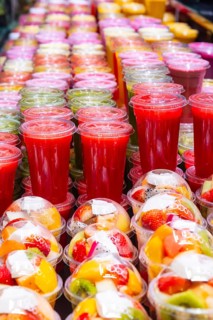 Smoothies and plastic fruit containers at La Boqueria market in Barcelona, Spain