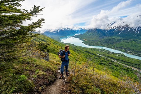 Climbers on a hiking trail, Slaughter Ridge Trail, view of snowy mountains and turquoise lake Kenai