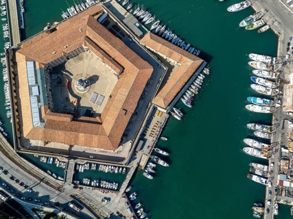 Drone captures of the pentagonal Lazzaretto of Ancona surrounded by harbor waters and boats. This