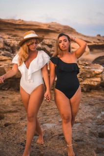 Lifestyle of a couple of Caucasian lesbian girls walking on the beach. Black and white bathroom