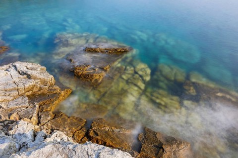 Crystal clear and turquoise water on the beach of Ustrine Bay on a sunny day on the island of Cres,