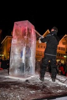 An ice sculpture is being created: ice carving street action as part of the long shopping night in