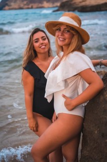 Lifestyle of a couple of lesbian Caucasian girls on the beach in summer. Seductive glances of the