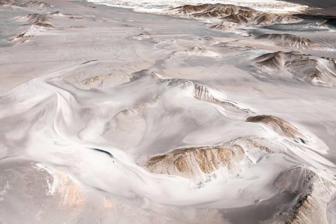 A breathtaking aerial shot of a vast desert landscape, showcasing intricate patterns formed by the