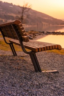 Wooden bench on the shore of a lake at sunset, quiet and relaxed atmosphere, Großer Alpsee,